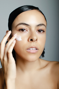  a person applying anti-aging cream