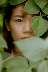 A woman's face surrounded by leaves indicating organic skincare 