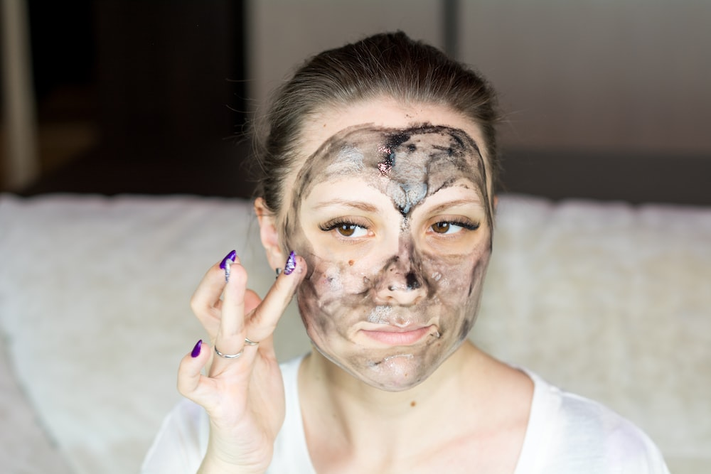 A woman applying cream to her face. 